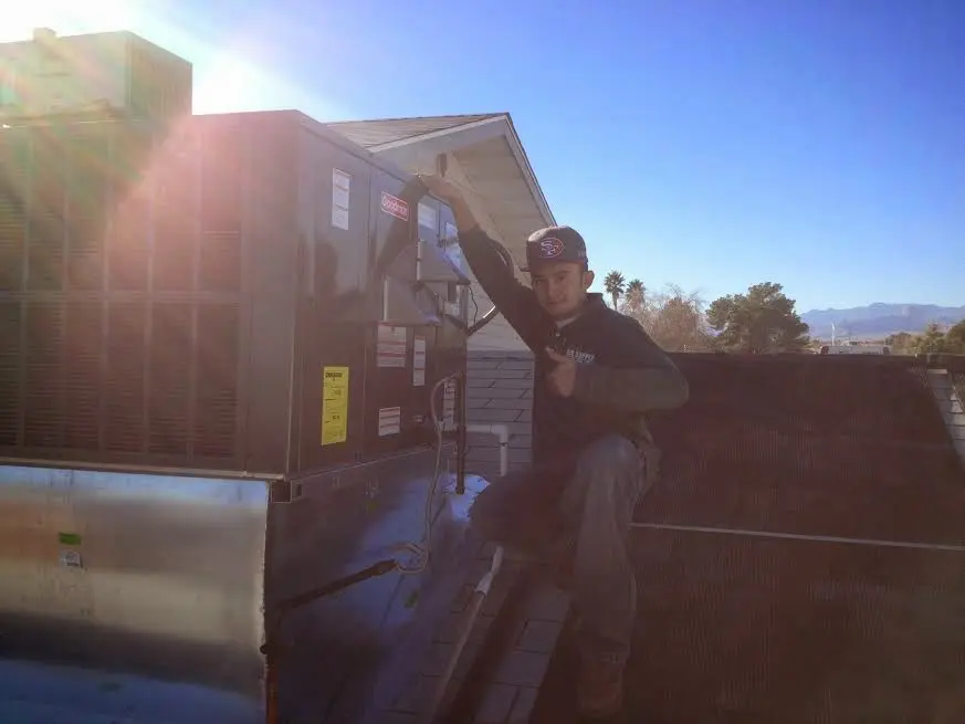 HVAC technician performing Air Duct Cleaning on a rooftop unit in Briar Chapel